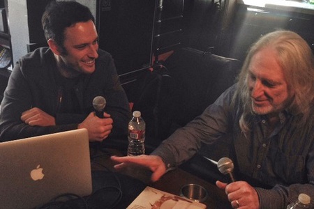 Albhy Galuten and his son Noah Galuten during a podcast holding mics.